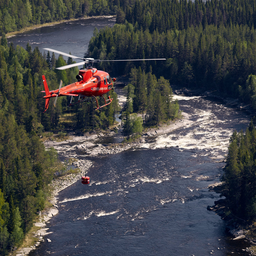 Helicopter flying over river in mountain area checking for hunters to rescue 